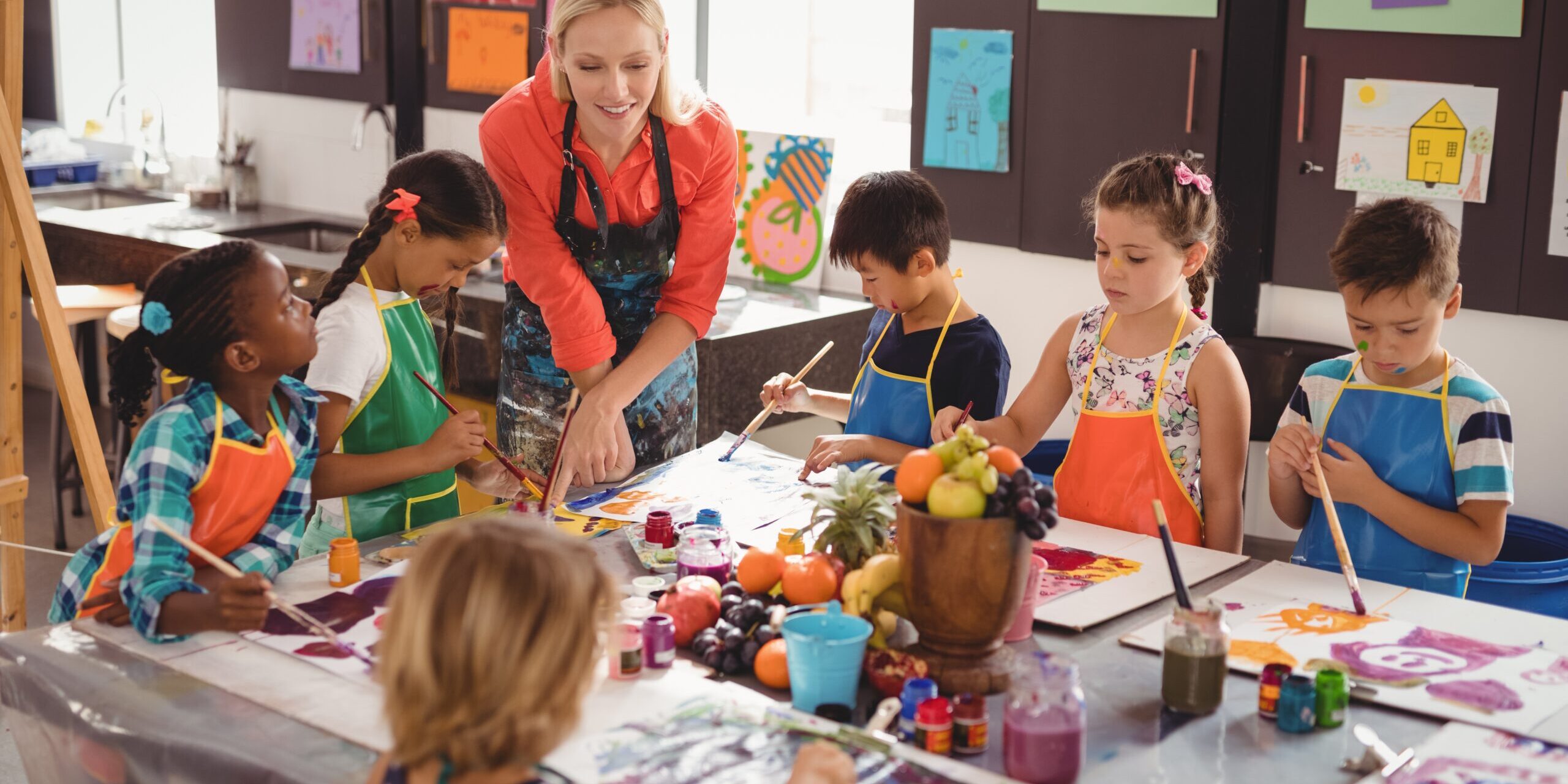 Kinder sitzen an einem Tisch und tuschen