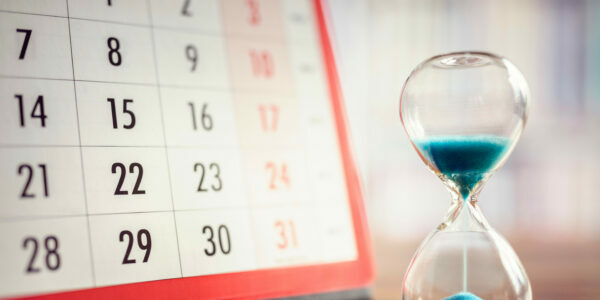 Eine Sanduhr vor einem Kalender